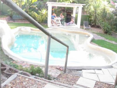Piscina estilo playa y área de barbacoa Image